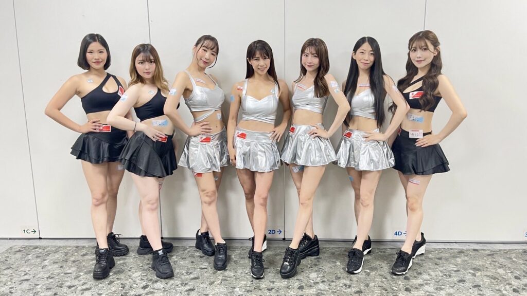 イーチケラウンドガールが、黒や銀の衣装でポーズを決めている