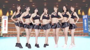 イーチケラウンドガールがボクシングのリング上で、黒の衣装や白や黒の靴でポーズをとっている