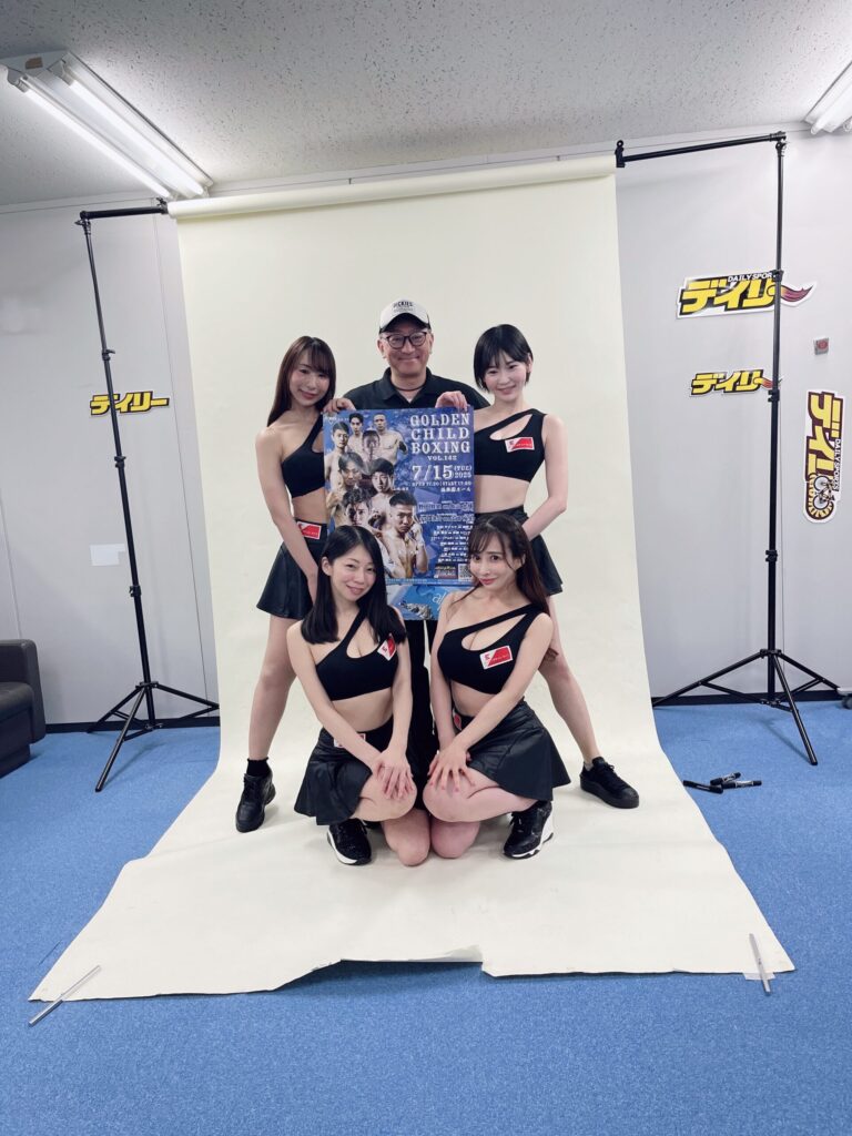 Golden Child Boxingのポスターを持った男性と、イーチケラウンドガール